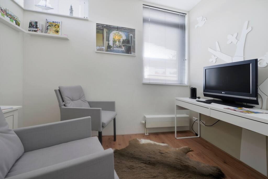 Aparte zitkamer, TV en koelkastje.