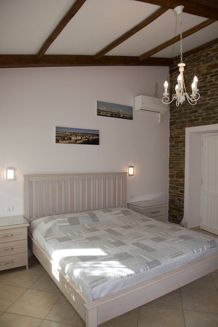 LETTI KING-SIZE, PARETI IN VERA PIETRA E TRAVI IN LEGNO