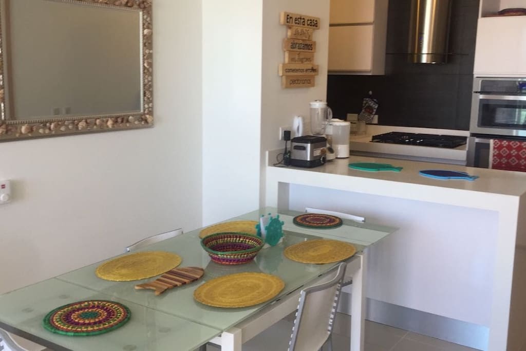 Dinning table & kitchen on the back / Comedor y cocina al fondo.