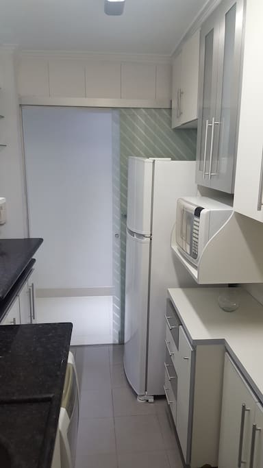 Fully equipped kitchen with microwave, fridge and glassware