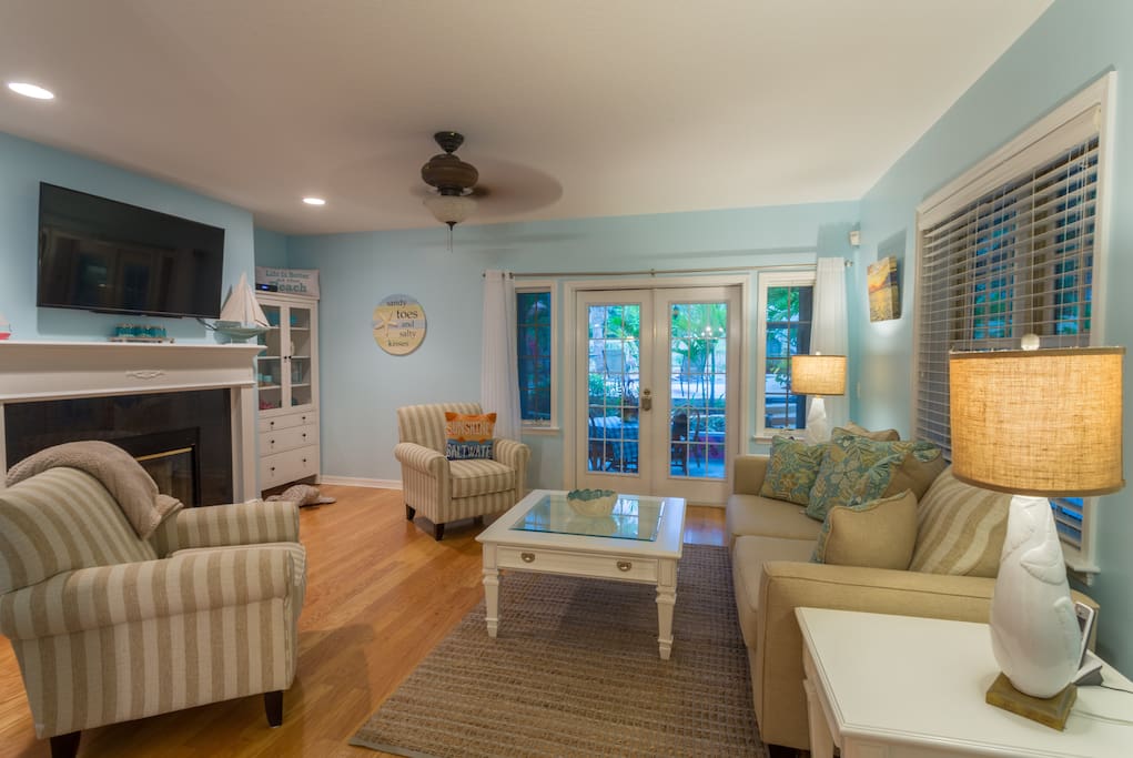 Spacious living room with pull out sofa and access to screened porch and pool