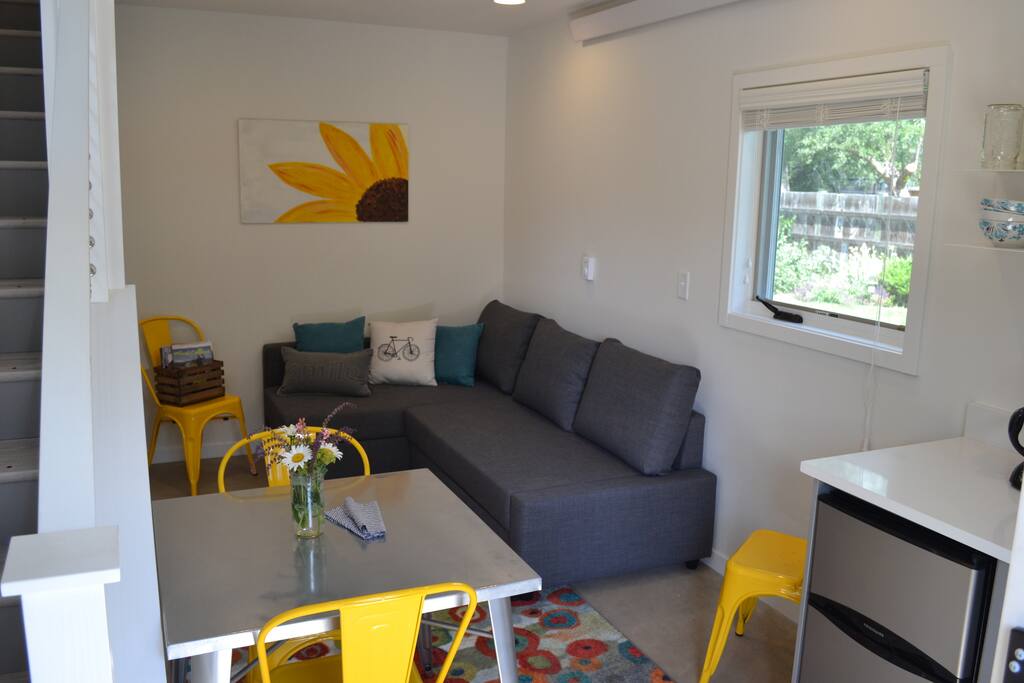 Walking in the front door, you have the kitchenette to the right and couch that converts to an additional bed. The stairs lead up to the bedroom and bathroom.