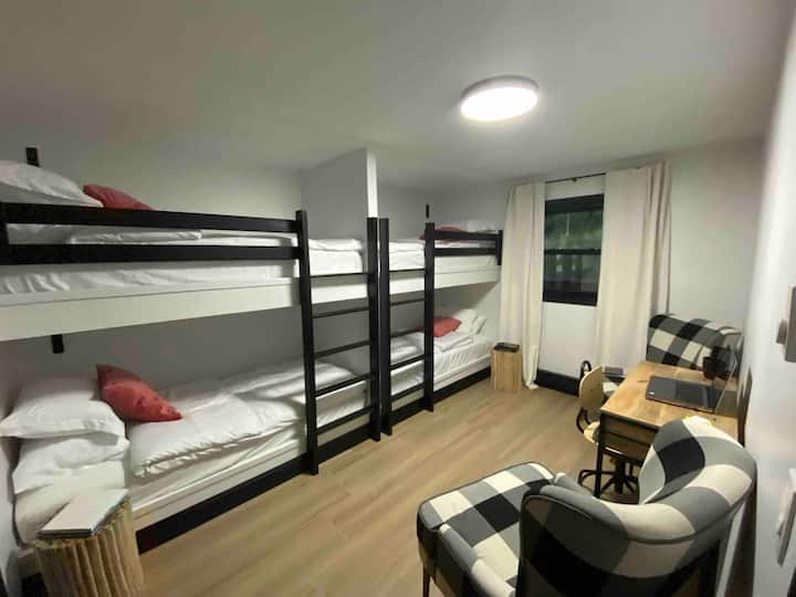 1er piso- Dormitorio 6: 
2 juegos de literas individuales xl con luces de lectura ajustables personales con USB, mesita de noche, escritorio portátil con silla, dos sillones, armario con estantes empotrados para equipaje y pertenencias personales. 