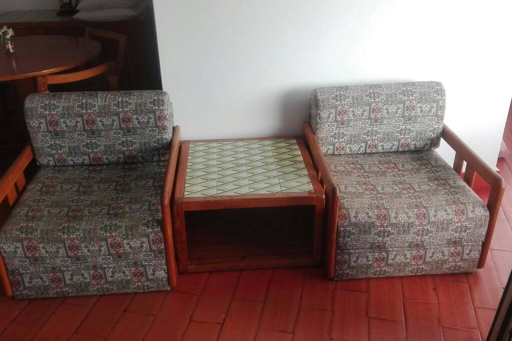 Sala com mais uma mesa de apoio e duas poltronas tipo cambalhota que fazem de camas pequenas para crianças.