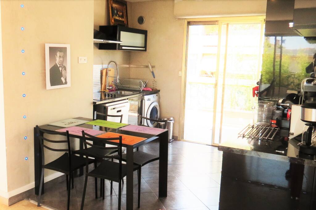 Cuisine design, équipement maximum et neuf. Au fond une autre large terrasse.