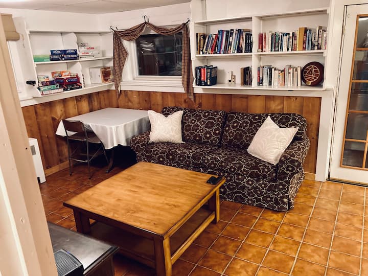 ห้องนั่งเล่น 2/ห้องเล่นเกมพร้อมเตียงโซฟาสำหรับรองรับผู้เข้าพักได้สูงสุด 8 คนตั้งอยู่ในชั้นใต้ดินที่สร้างเสร็จแล้ว ประตูแยกจากห้องนอนในอีกครึ่งหนึ่ง รูปประตูทางขวามือเป็นทางเข้าส่วนตัวจากทางเดิน 