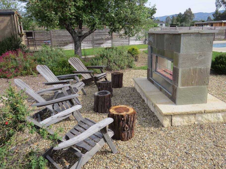 Adirondack chairs around outdoor fireplace