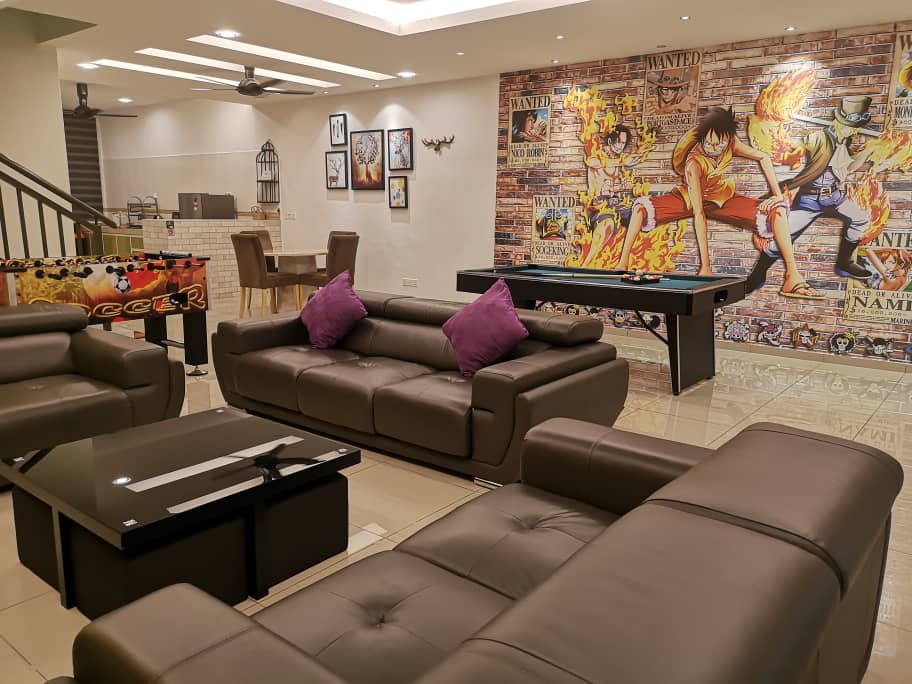A modern living space features sleek leather sofas adorned with purple cushions, complemented by a glass coffee table. A striking mural of animated characters adds vibrancy to the room. In the background, a dining area with wooden chairs and a pool table are visible.