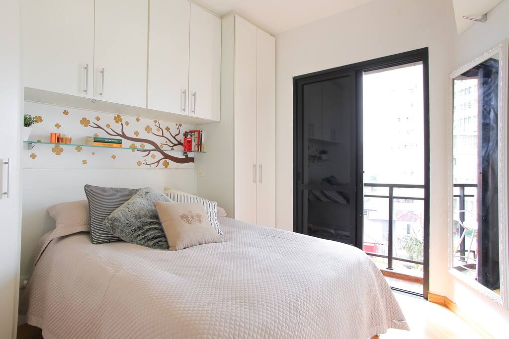 Quarto aconchegante e iluminado com varanda