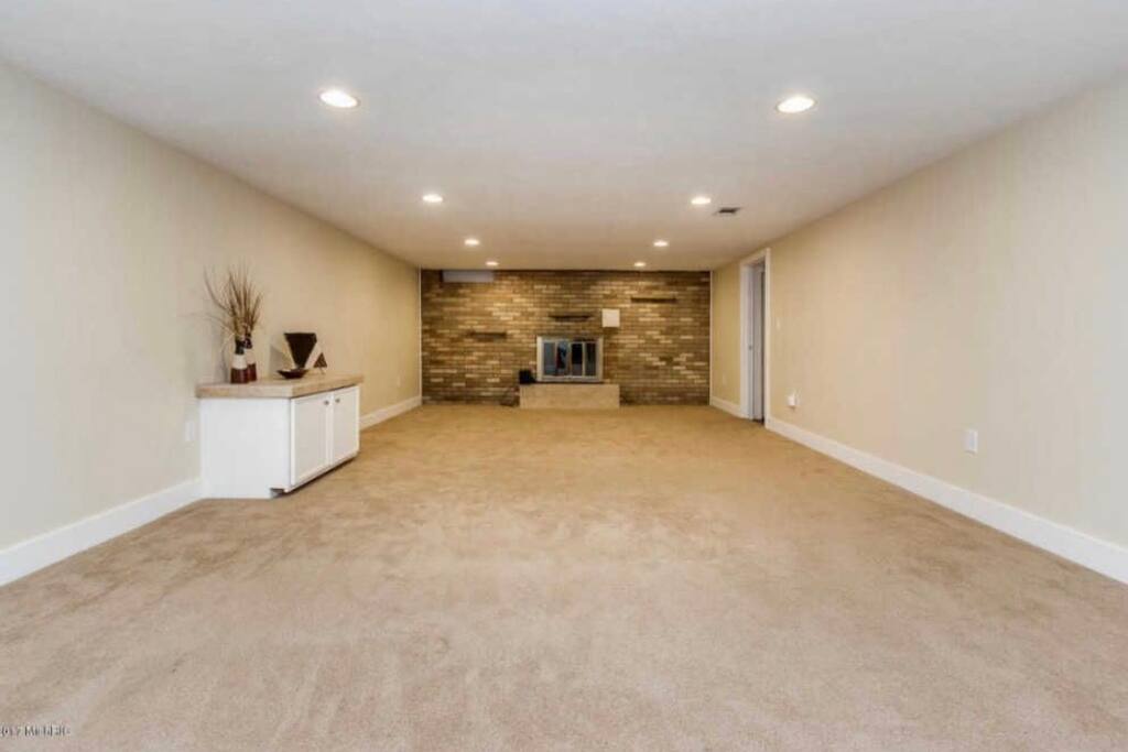Family room with sofa, TV, and room for up to 4 single bed. Currently shown empty to see actual size.