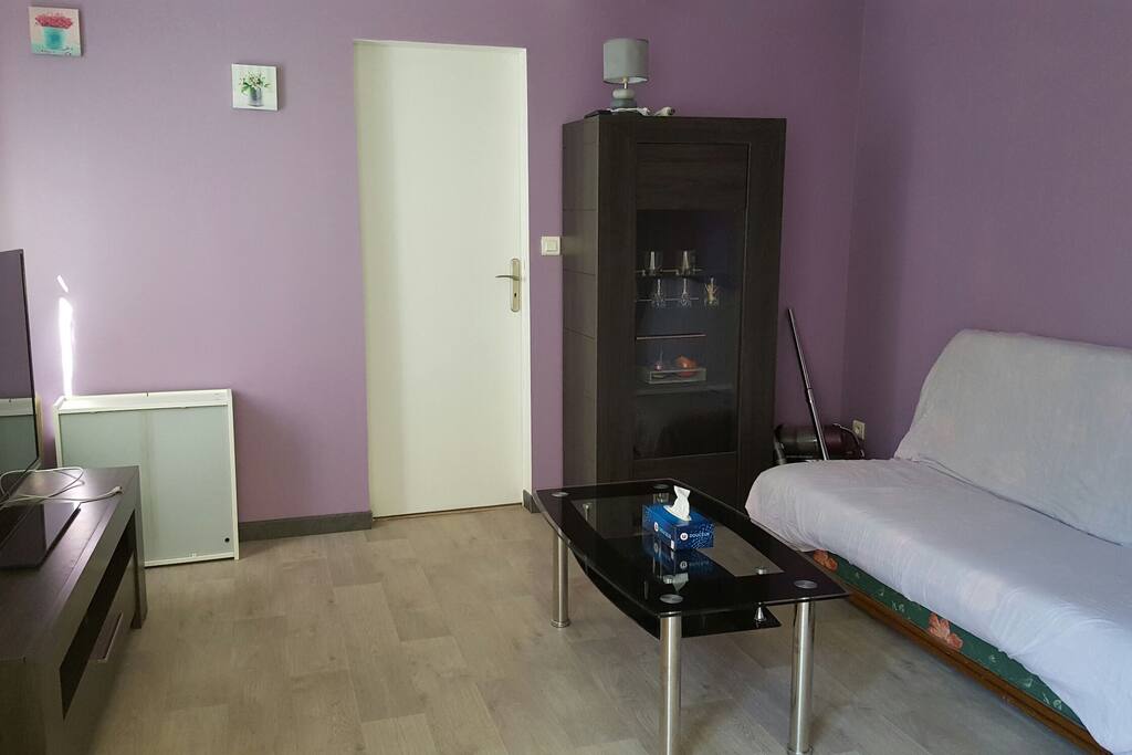 Canapé clic clac avec assez de place dans le salon pour y mettre un matelas gonflable.