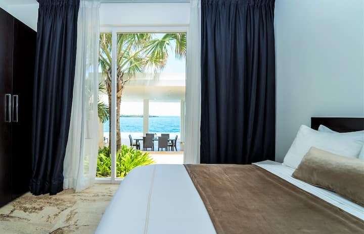 Dormitorio con cama tamaño king, baño privado con ducha/bañera, aire acondicionado, TV, caja fuerte y balcón privado.