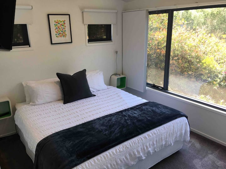 Spacious bedroom with king size bed, television, ceiling fan, heater, and both internal and external blinds for your sleeping comfort.