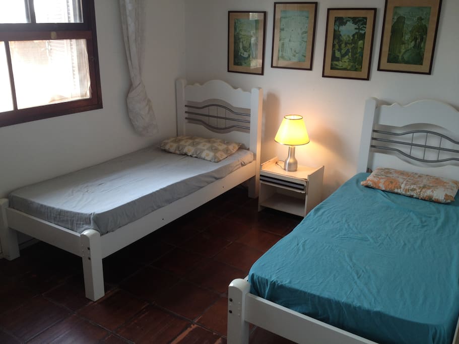 Quarto branco, 2 camas de solteiro.