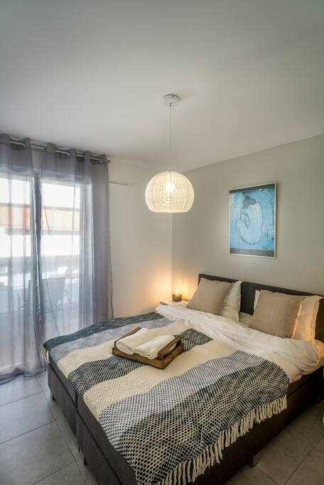 De slaapkamer heeft schuifdeuren naar het balkon