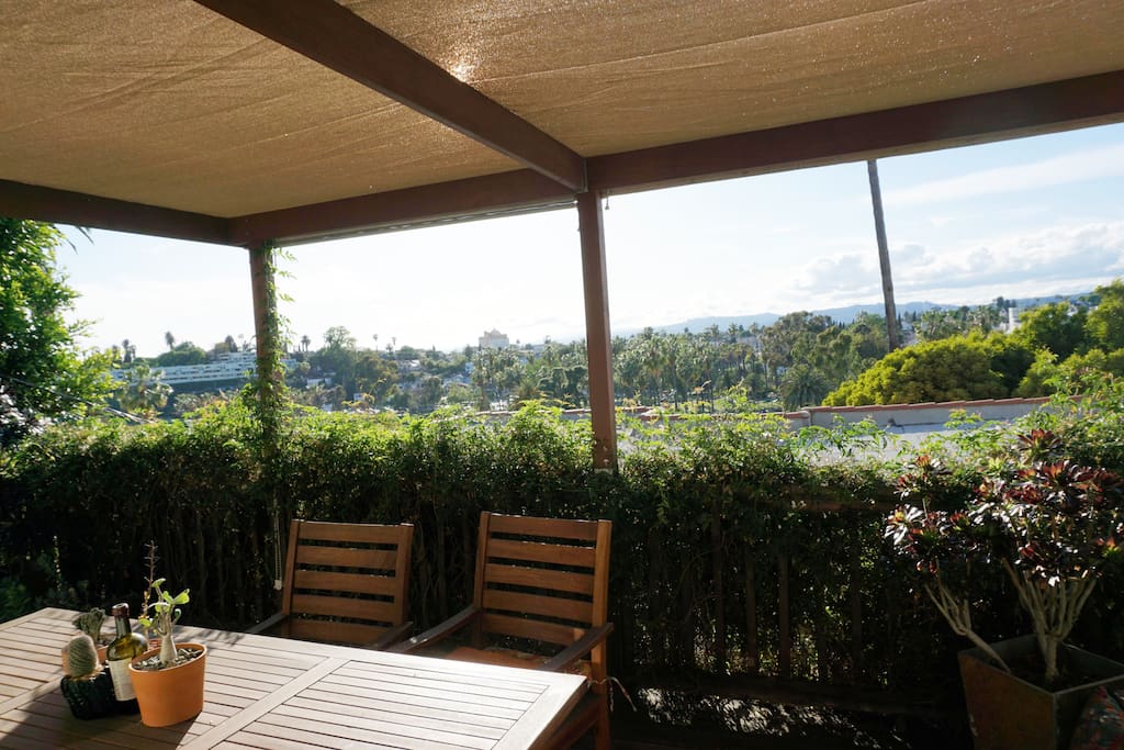 Spacious redwood deck just off the living room. It has a Westerly view looking over Echo Park Lake. Half is covered with a beautiful pergola for shade. There are numerous potted plants and a teak dining table set.
