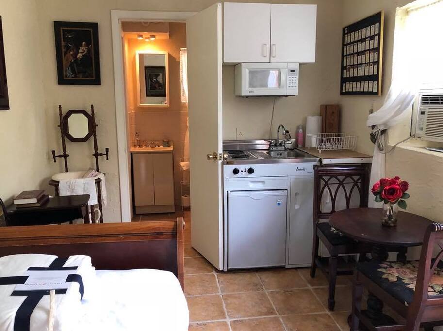 Kitchenette set with microwave, stove, and refrigerator.