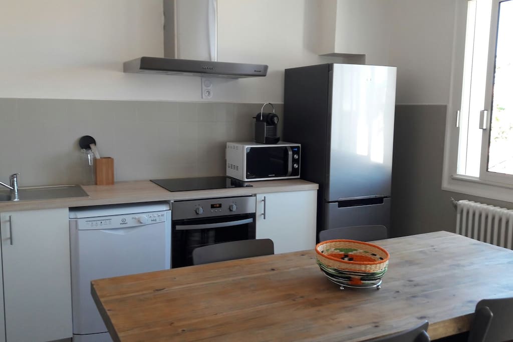 Cuisine équipée avec un accès balcon ,jardin et terrasse par un escalier extérieur.