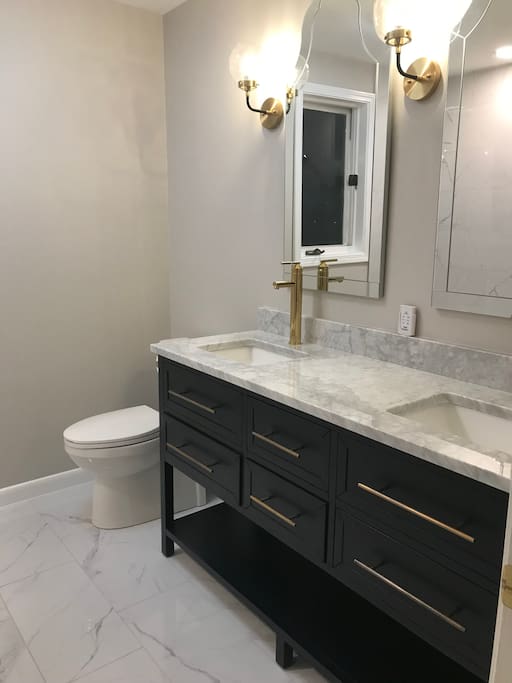 Bathroom with double sink, heated floors and Bluetooth speakers.