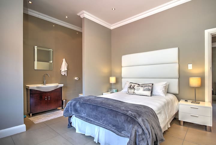 חדר שינה ראשי עם מקלחת, כיור ושירותים.