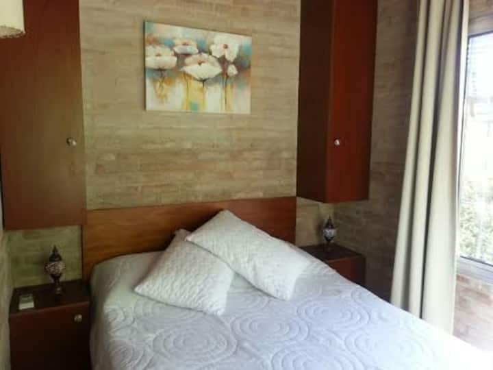 卧室配有双人床，配有空调，两面墙上有2扇大窗户。