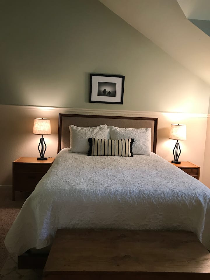 Este es el tercer dormitorio que llamamos este cedro con vistas a dos cedros altos por la ventana. Este dormitorio tiene una cama tamaño queen, dos mesas laterales, vestidor y un armario.