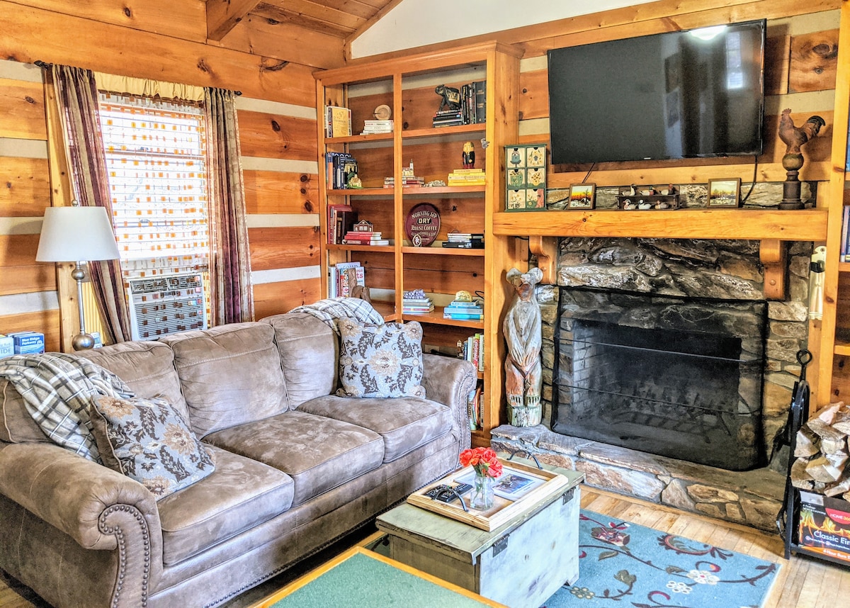 The view of the living room, with the queen size memory foam sleeper sofa and wood-burning fireplace.  Enjoy a movie on the flat screen. 