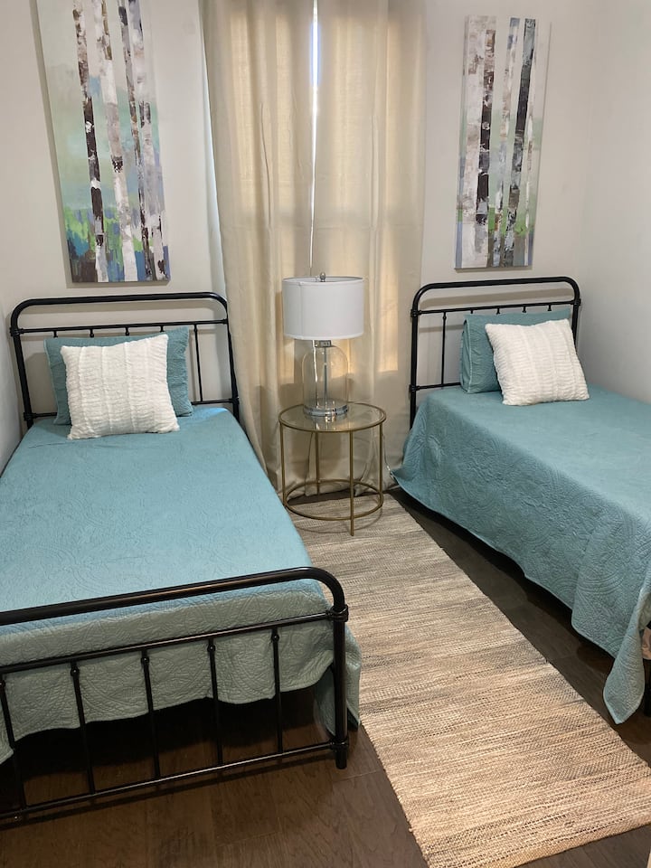 חדר שינה בקומה הראשונה עם שתי מיטות נפרדות. 