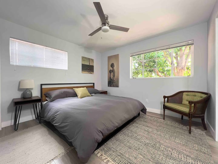 Kitanda cha ukubwa wa mfalme na mtazamo wa bustani kutoka chumba cha kulala cha bwana. 