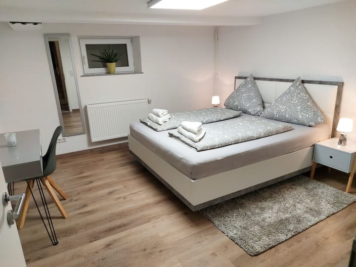 Quarto com cama de casal e escrivaninha