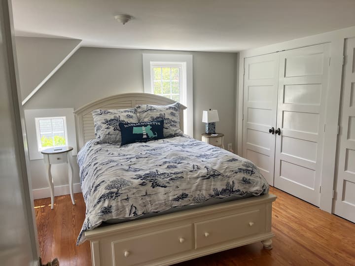 Dormitorio queen con una sala de estar y mucho espacio en el armario.