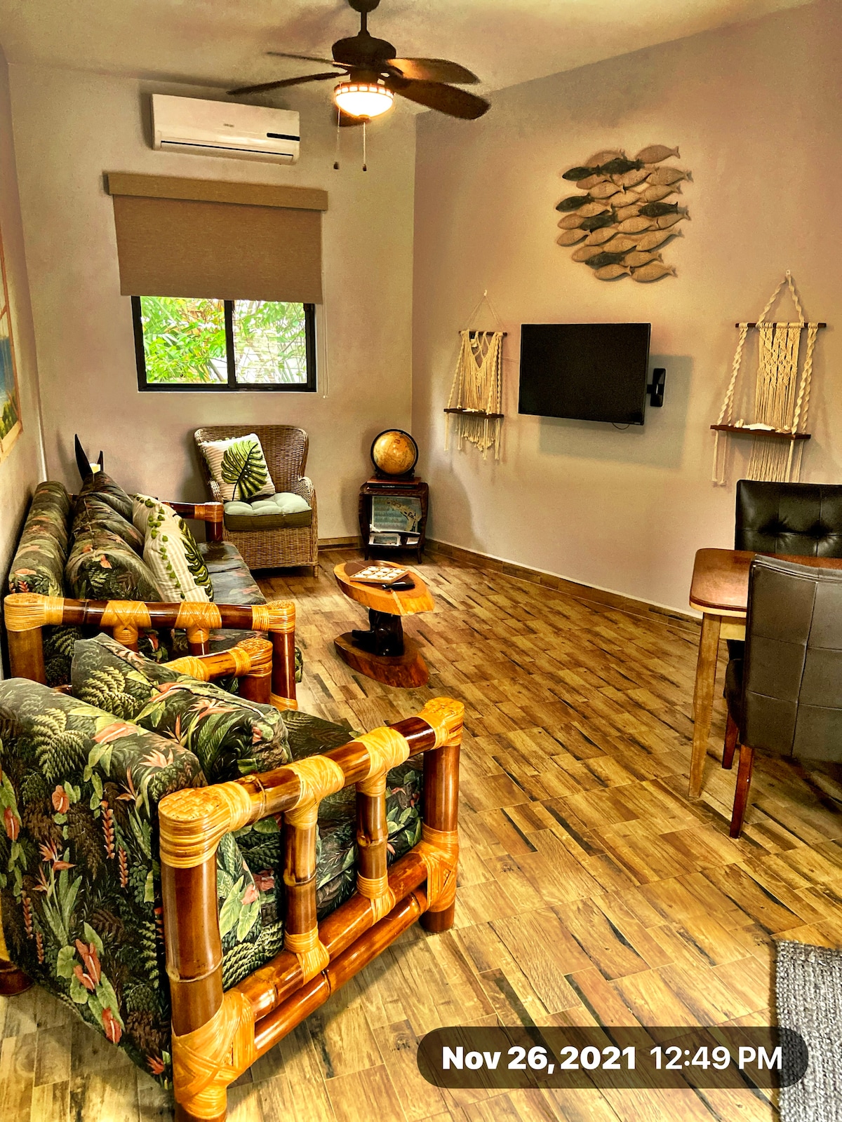 Living room with mounted cable TV and table with two dining chairs