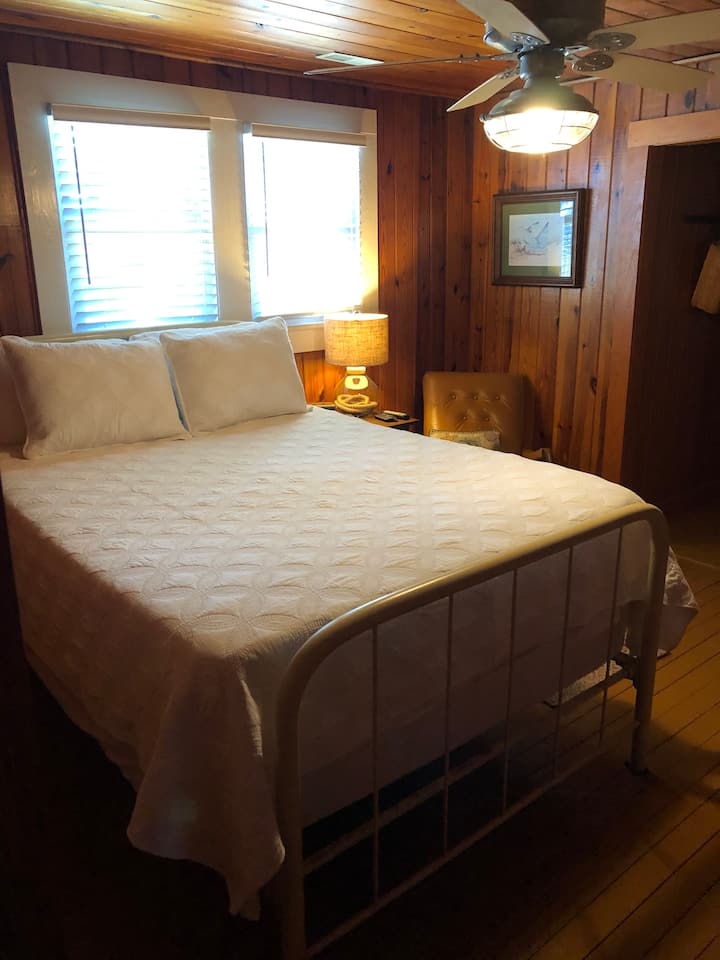 Quarto com banheiro anexo. O chuveiro neste banheiro é um chuveiro vertical
