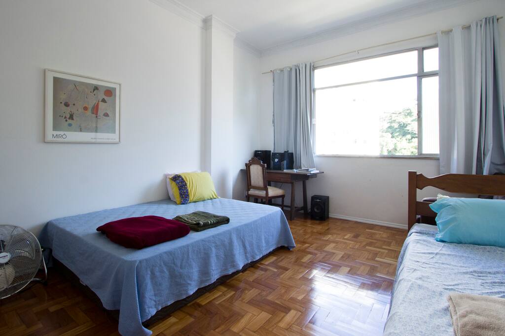 Quarto com uma cama de casal e uma de solteiro. Vista para o Cristo