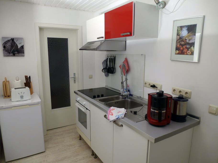 Vollausgestattete Küche mit Ceranherd, Kühlschrank mit Gefrierfach, Kaffeemaschine, Wasserkocher und reichlich Geschirr und Besteck. Essplatz für 2 Personen.
