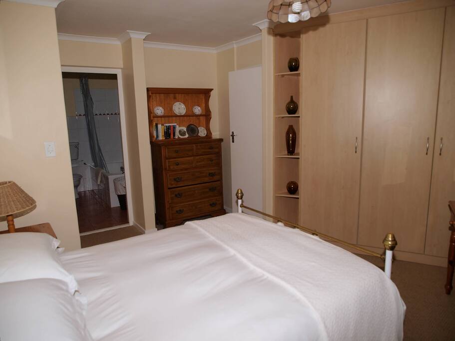 Fitted cupboards with hanging space, shelving & chest of drawers, leading into bathroom en suite
