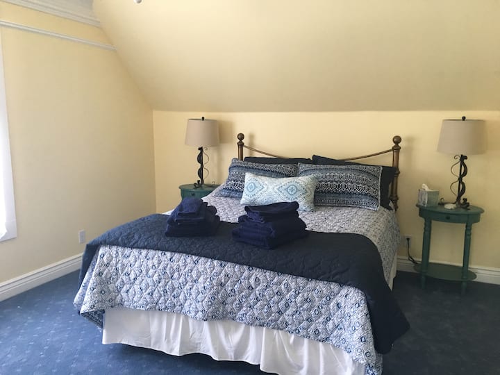 Upstairs bedroom with queen and daybed across the room in the dormer.
