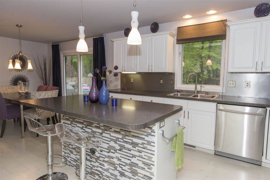 Kitchen and dining area with seating at the breakfast bar and oversize farmhouse dining table