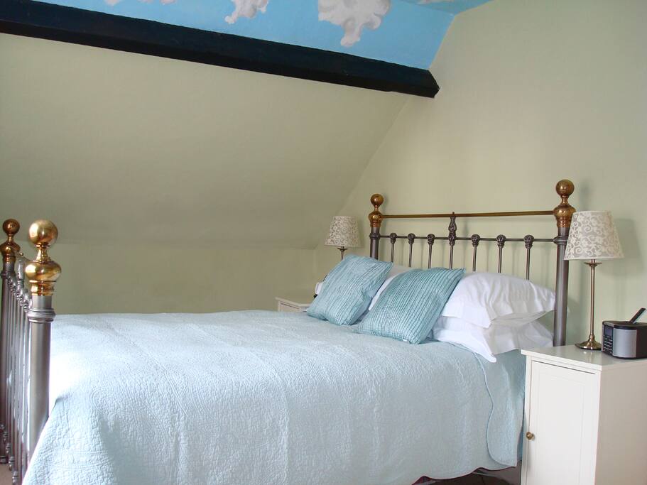 Church view bedroom with one queen bed, single bed & marble topped washbasin