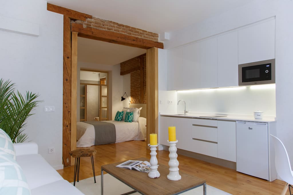 Nos gusta el concepto abierto que aporta el marco de madera entre el dormitorio y el salón-cocina.