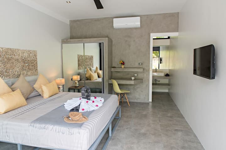 Chumba cha kulala cha rangi ya manjano na kijivu. 
Vitanda viwili au kitanda cha ukubwa wa King (sentimita 180). Kiyoyozi + feni + sanduku la usalama + bafu la chumbani. CHUMBA CHA KULALA N°3
Chumba hiki kinaweza kutumika kama sebule pia.

Chumba hiki kinawasiliana na jikoni. 