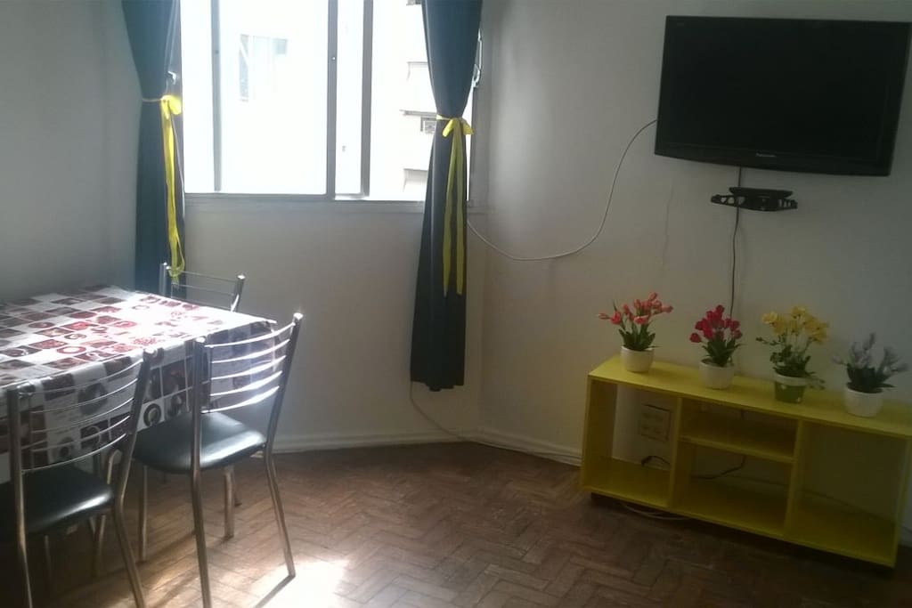 Sala com mesa de jantar e TV a cabo