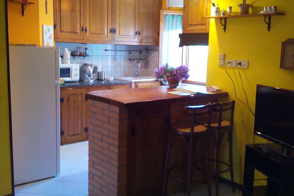 la cucina con bancone e 2 sgabelli