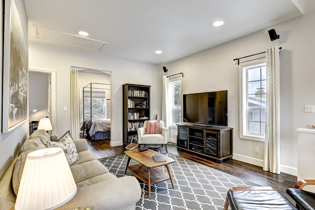 Main room with 55" TV and surround sound. The books have been moved to the bedroom and there is now a sliding barn-style door to provide privacy for the bedroom