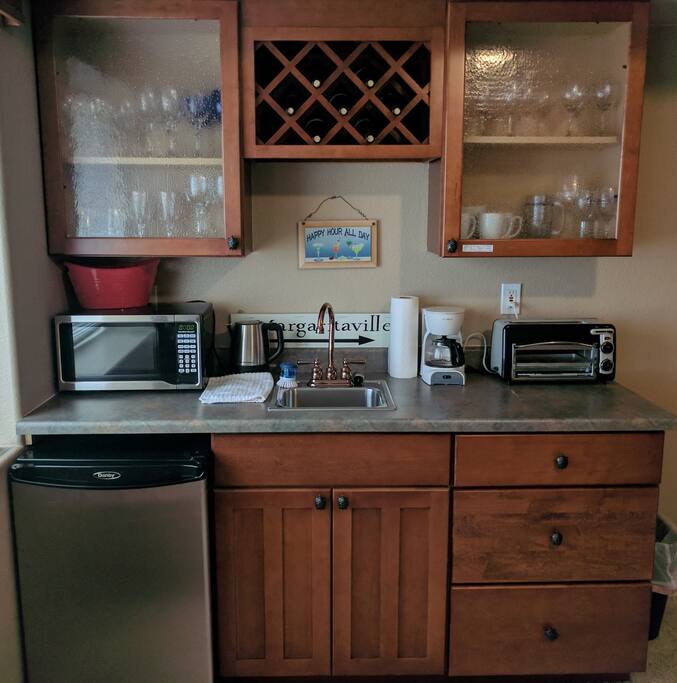 Wet bar with mini fridge, toaster oven, microwave, and lots of breakfast items, snacks, and drinks