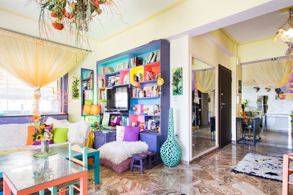 Open plan living area with left living room, middle the entrance and right the kitchen area