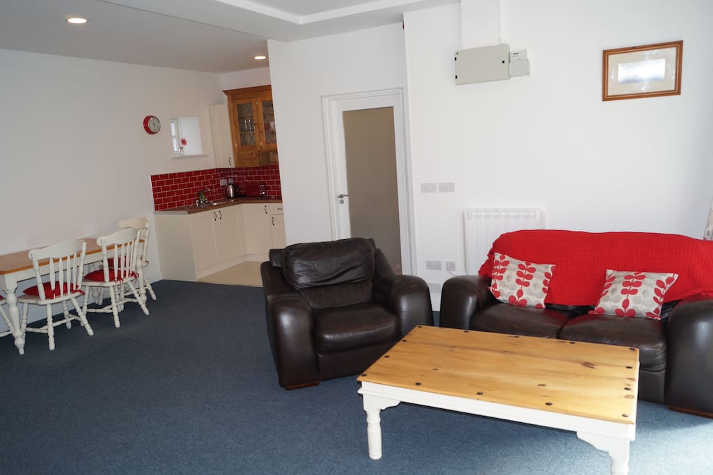 This photograph shows our studio Apartment from the the entrance. The door in the middle of the shot, leads to the lavatory and shower room, which is fully stocked with fresh towels and shower gels. The kitchen area can be seen to the left, while there is a table and chairs where guests can enjoy meals.