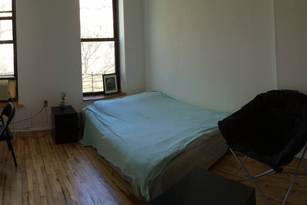 Full sized bed in the bright sunny bedroom