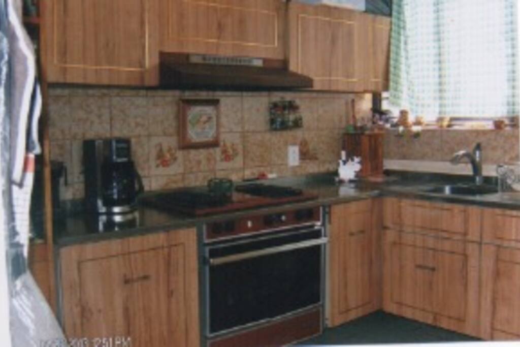 Cocina equipada con linea blanca y utensilios de cocina, disponibles.