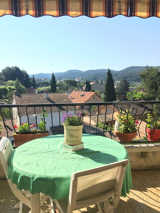 un balcon plein de fleurs en pot de toutes les couleurs.